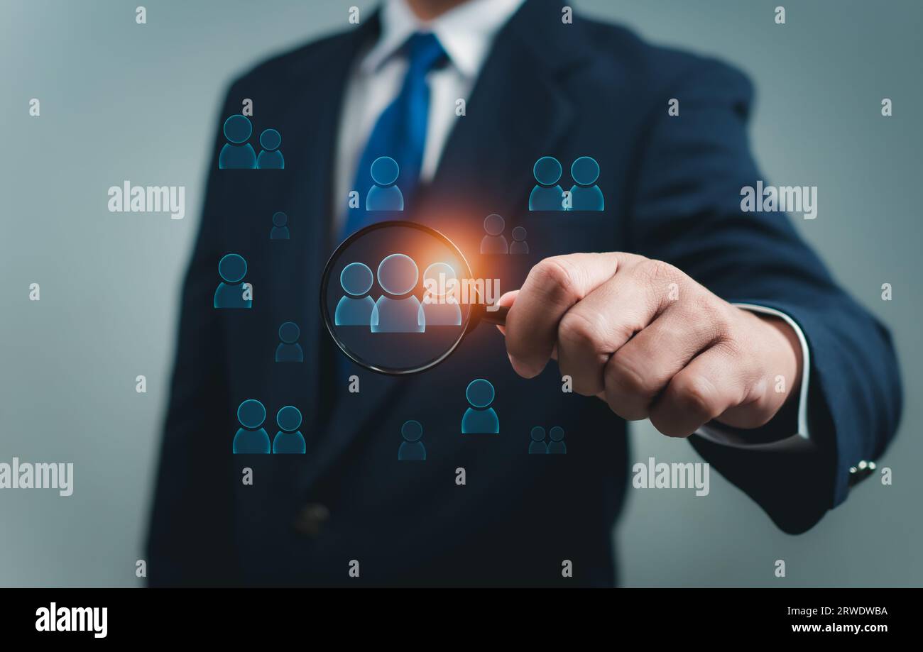 Business people use a magnifying glass to find business target groups
