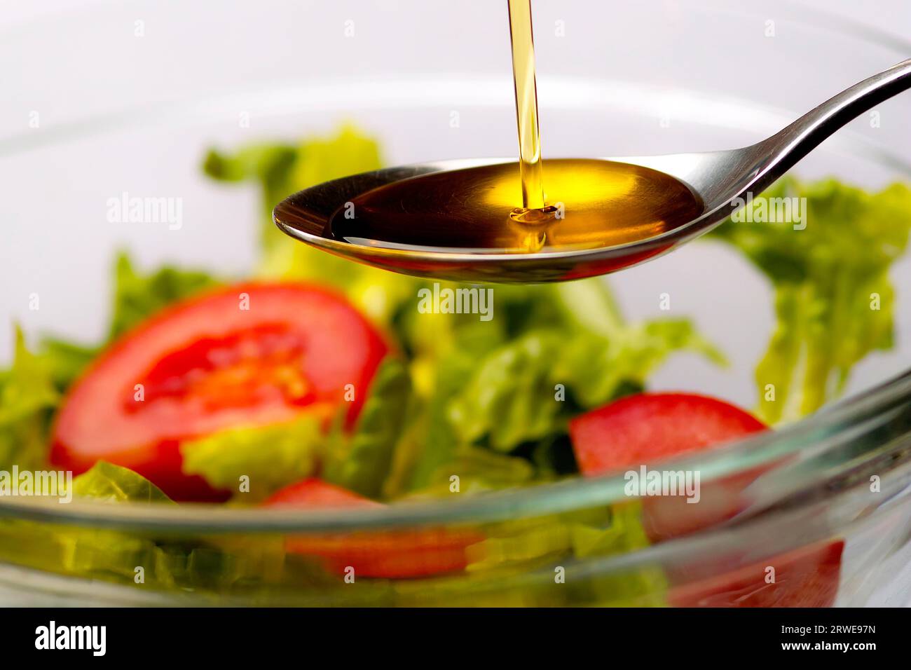 Olive oil flows into a spoon Olive oil flows into a spoon Stock Photo