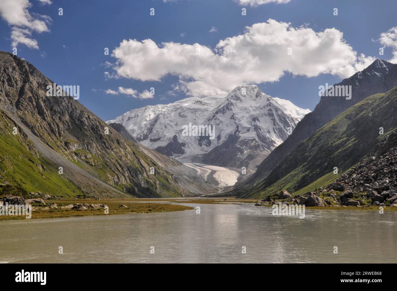 Picturesque view of green slopes and snow-covered peaks of Tian-Shan ...