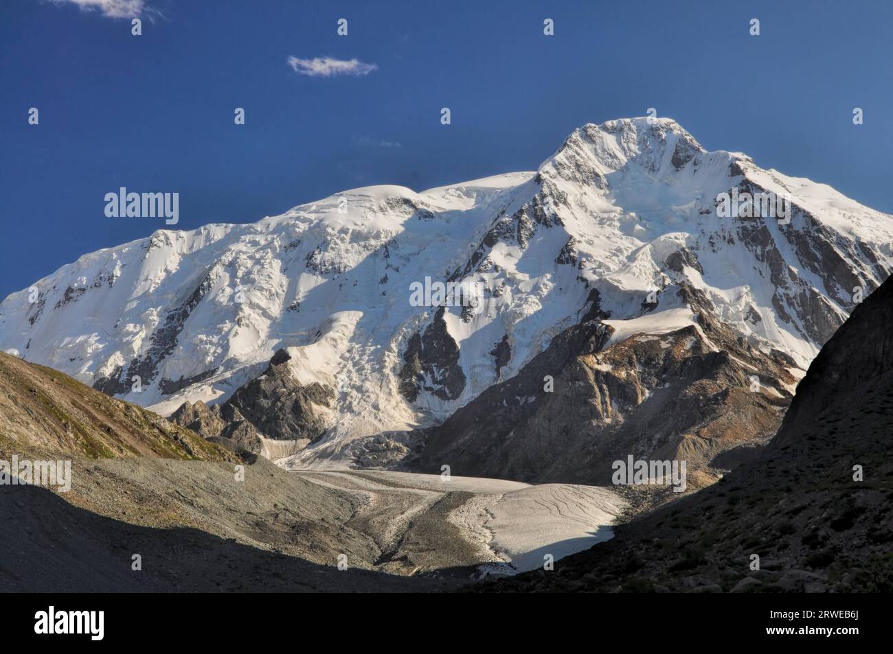 Panoramic view of sunlit snow-covered slopes of Tian-Shan Mountains ...