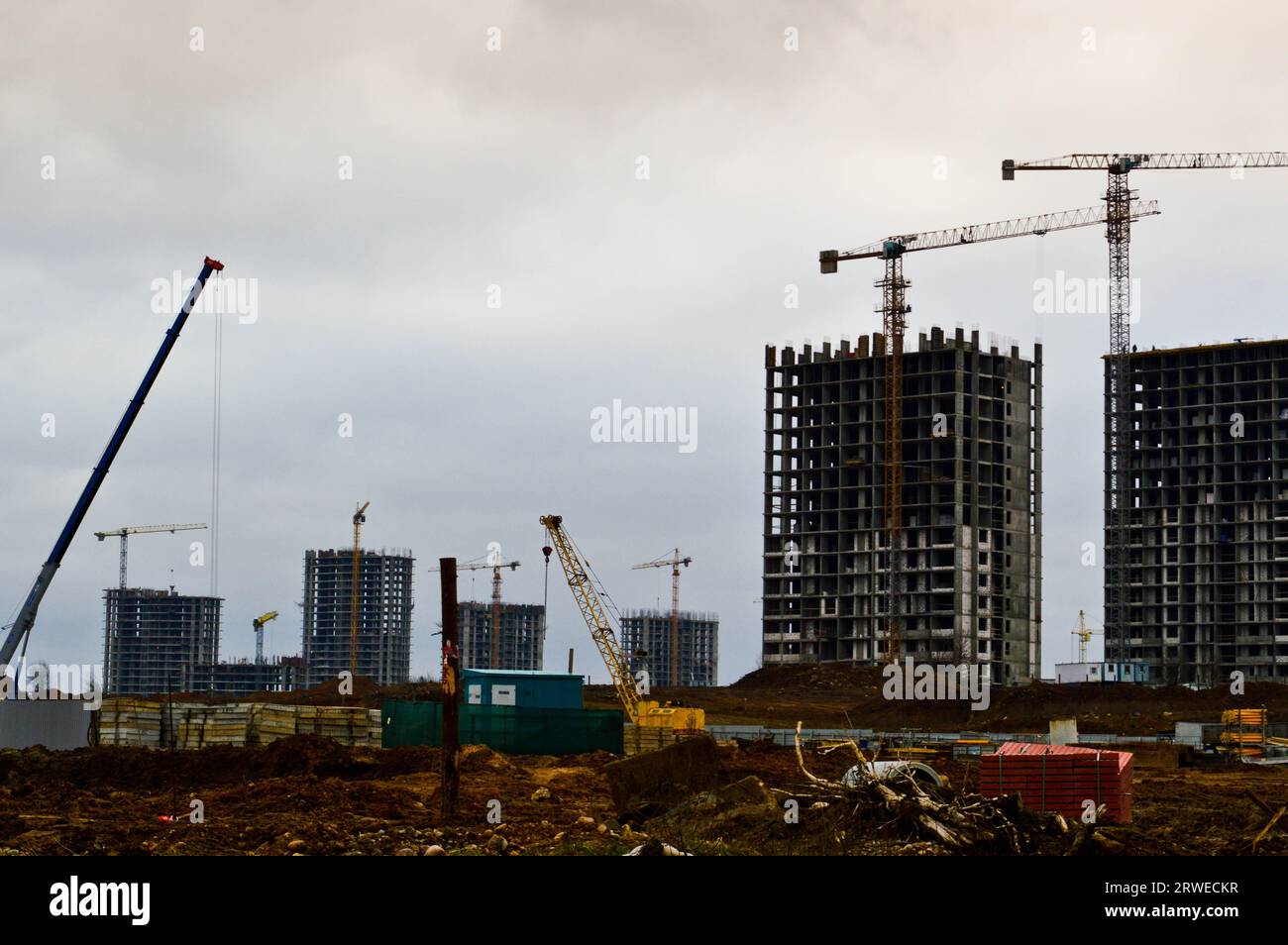 Construction of large modern monolithic frame houses, buildings using industrial construction equipment and large high cranes. Construction of the bui Stock Photo