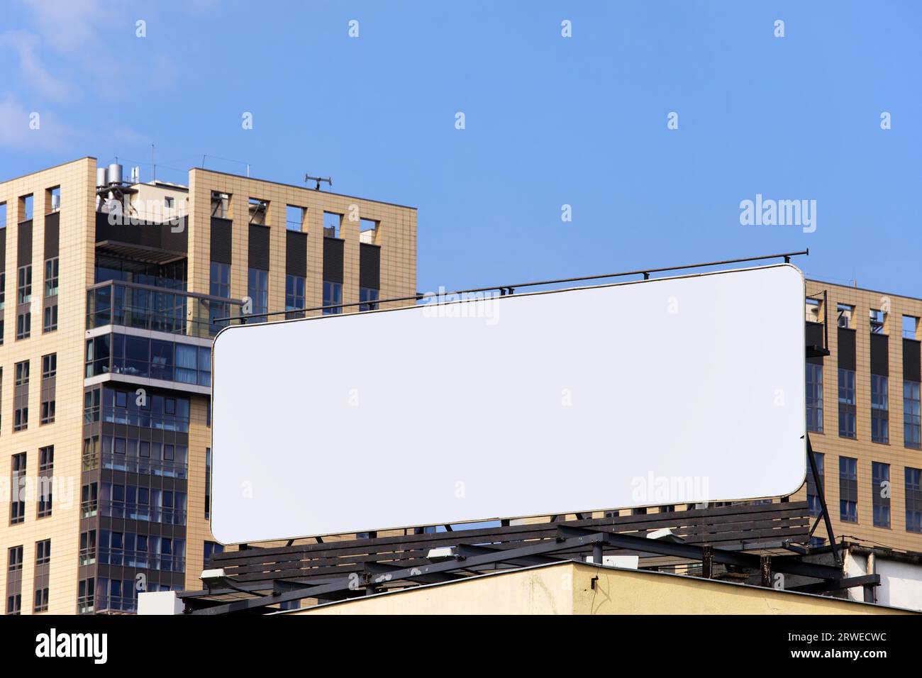 Large blank billboard on a building roof in the city downtown Stock Photo