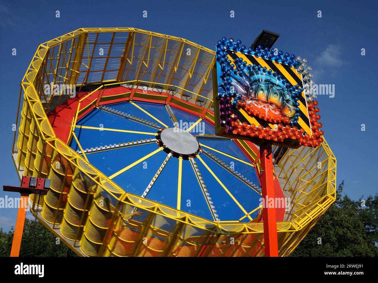 Colourful rotating carousel in full swing, background blue sky Stock Photo