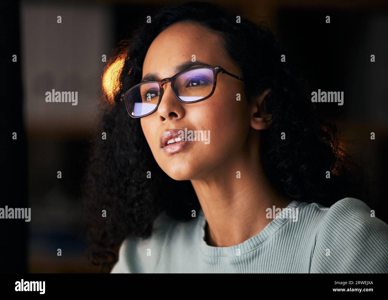 Business woman, glasses and reading on computer for programming, software or information technology solution. Young night programmer in screen Stock Photo