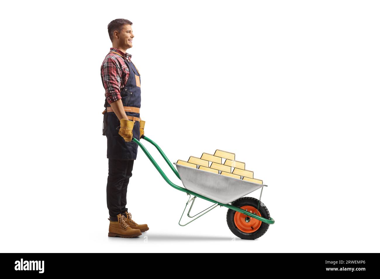 Full length profile shot of a farmer standing with gold in a wheelbarrow isolated on white background Stock Photo