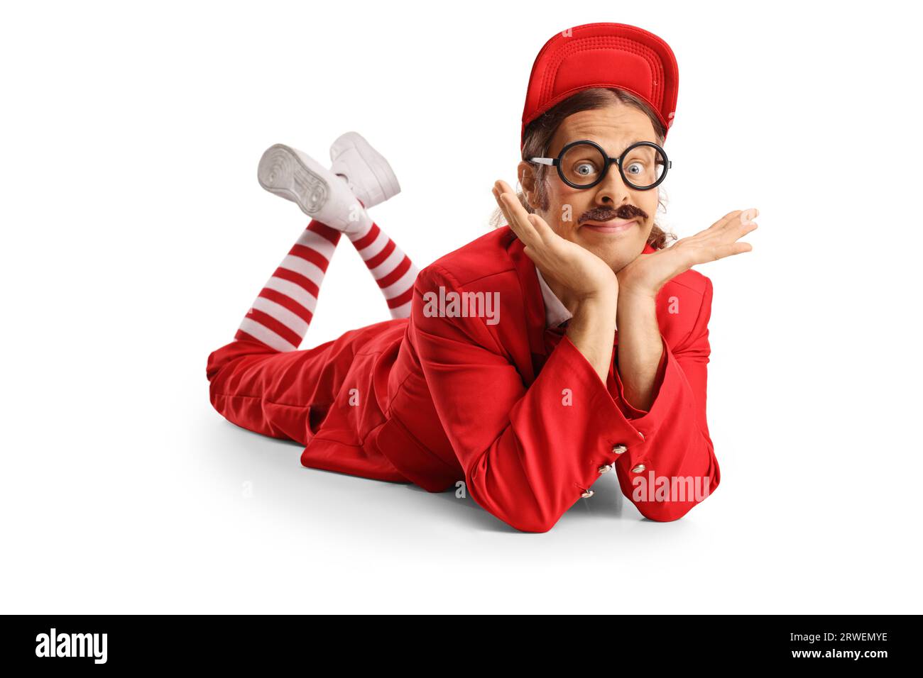 Funny entertainer in a red suit laying on the floor and looking at camera isolated on white background Stock Photo