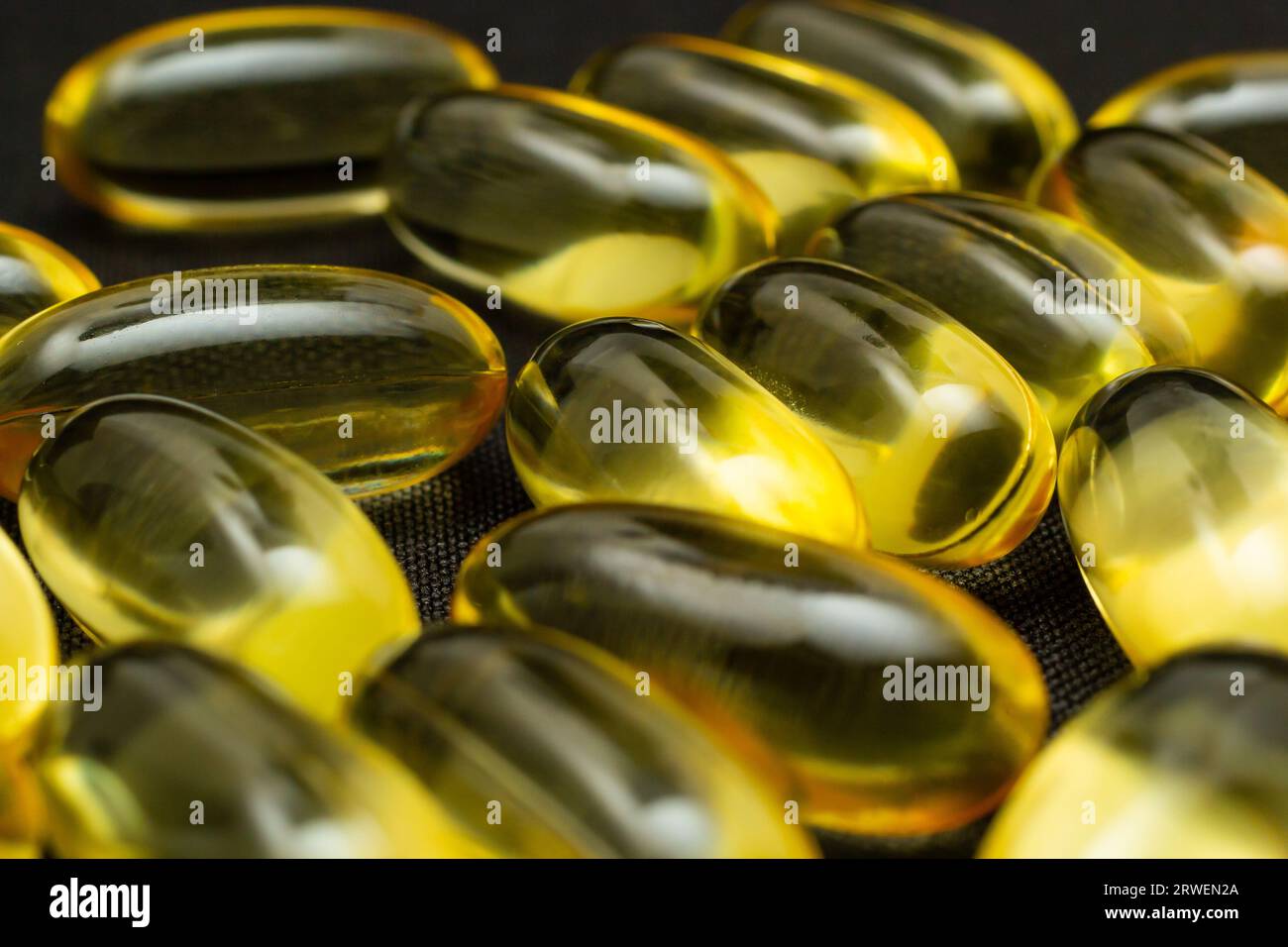 Macro Close up of Omega 3 gel capsule on a reflective black background