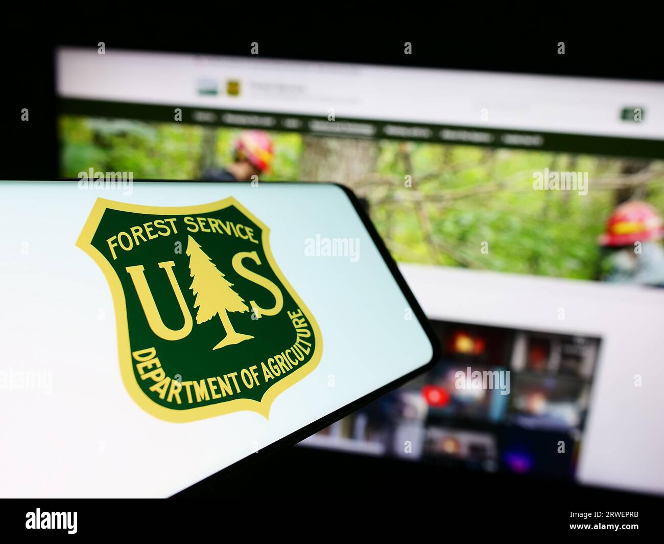 Smartphone with logo of United States Forest Service (USFS) on screen in front of website. Focus on center of phone display. Stock Photo