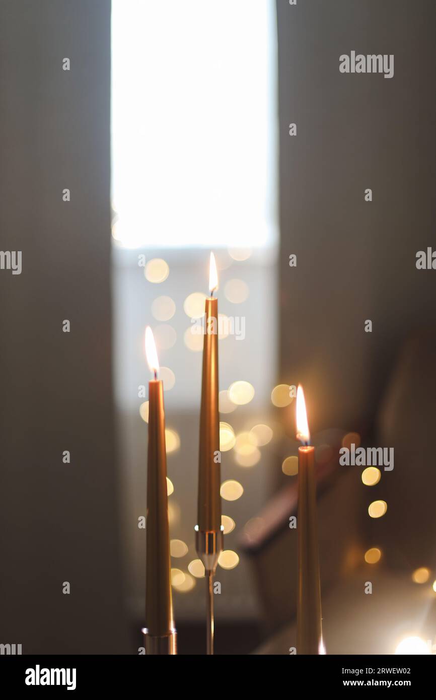 Beautiful composition with burning wax candles on table. Elegant golden