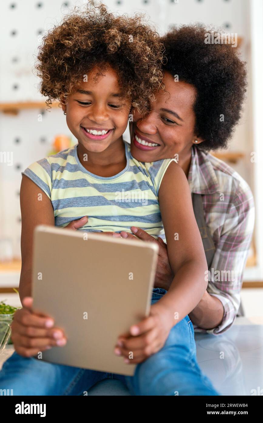 Portrait of happy black woman and her cute preteen daughter having fun together at home Stock Photo