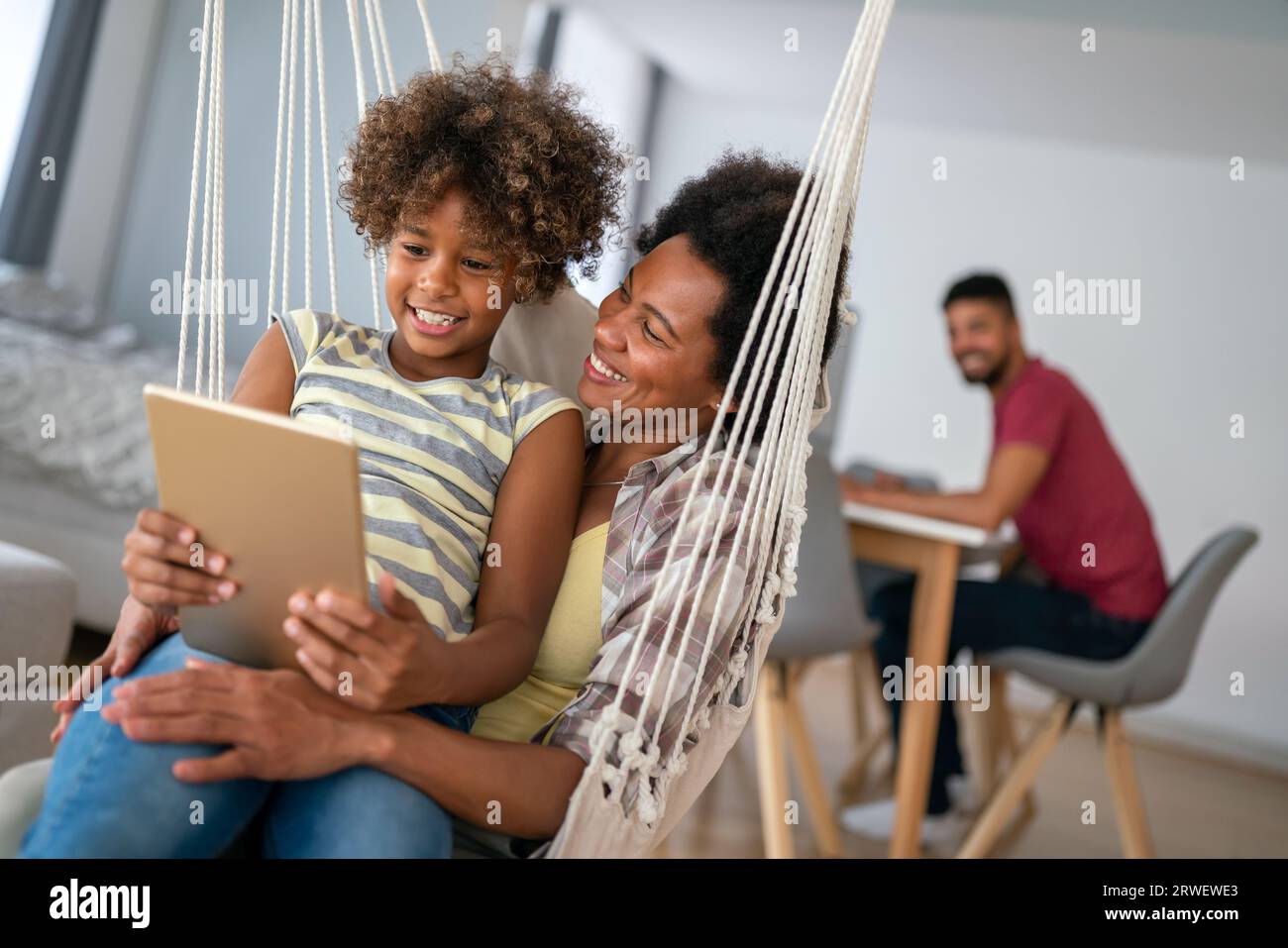 Happy african american preeteen girl using digital tablet for education, fun at home. Family concept Stock Photo