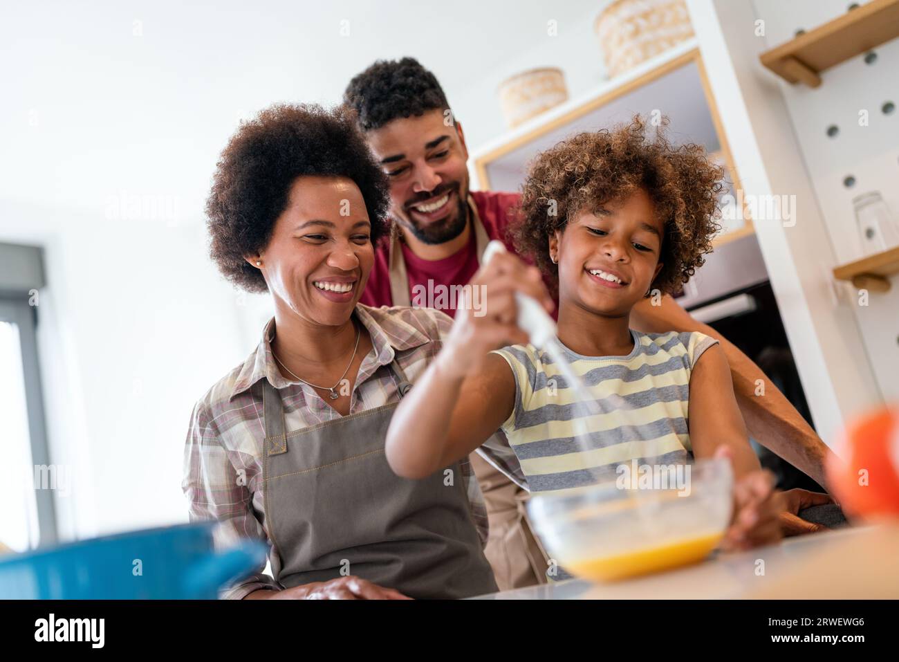 Happy african american family preparing healthy food in kitchen, having fun together on weekend Stock Photo