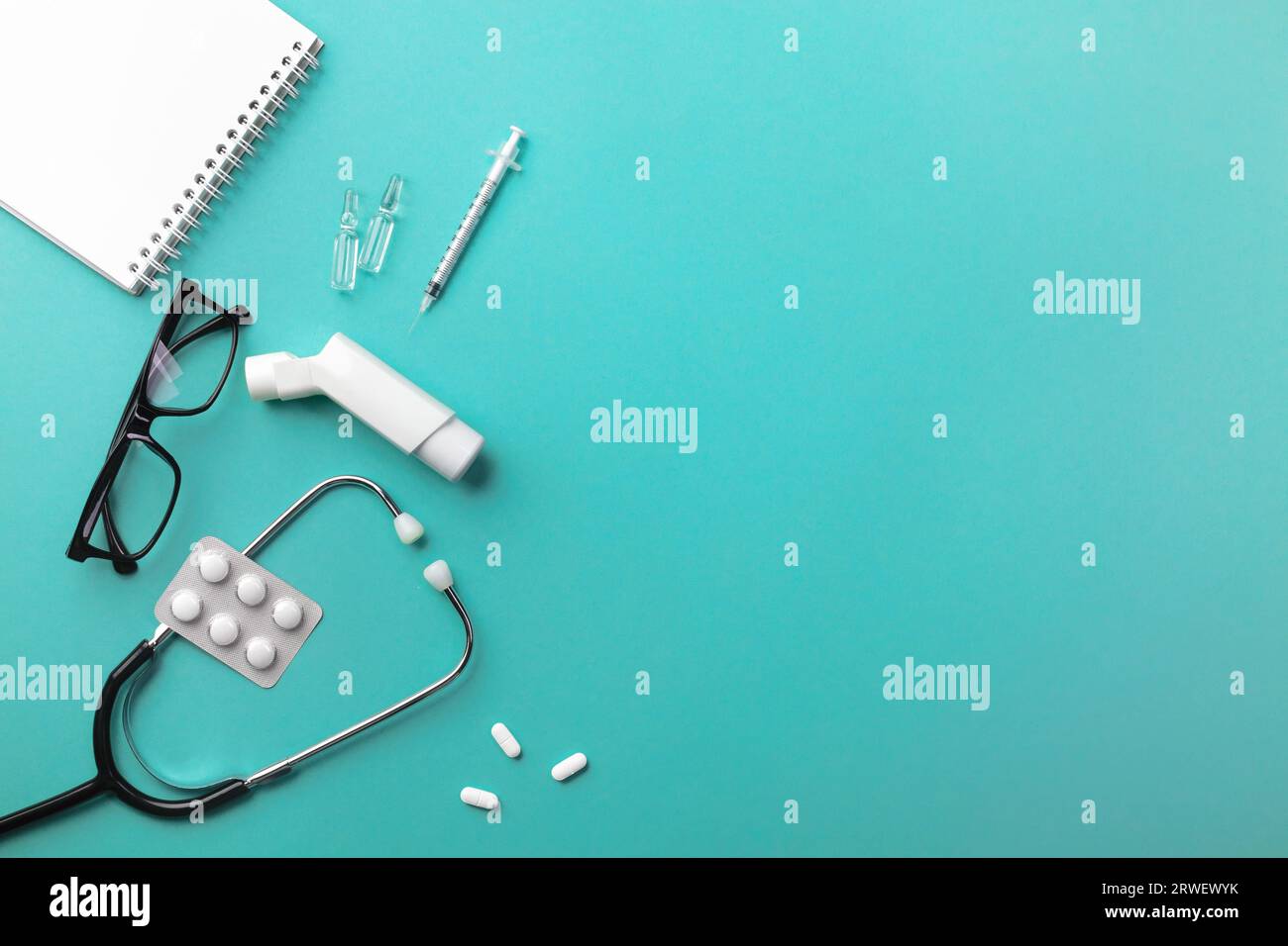 Stethoscope in doctors desk with keyboard, syringe, ampoules, inhaler ...