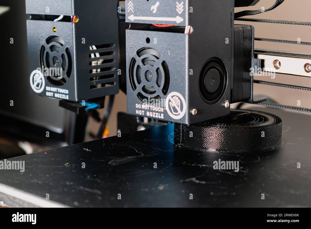 Dual extruder 3d printer printing a black model, idex technology Stock