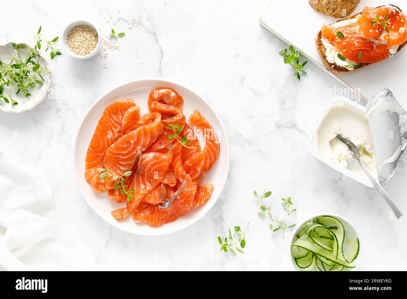 Salted salmon sliced on plate on a white background, top down view Stock Photo