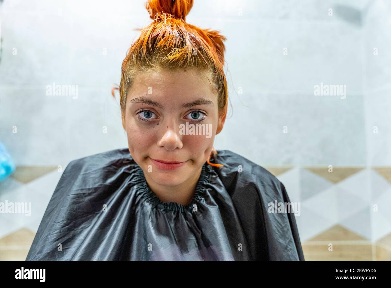 a teenage girl dyes her hair red. The process of dyeing hair red. Self