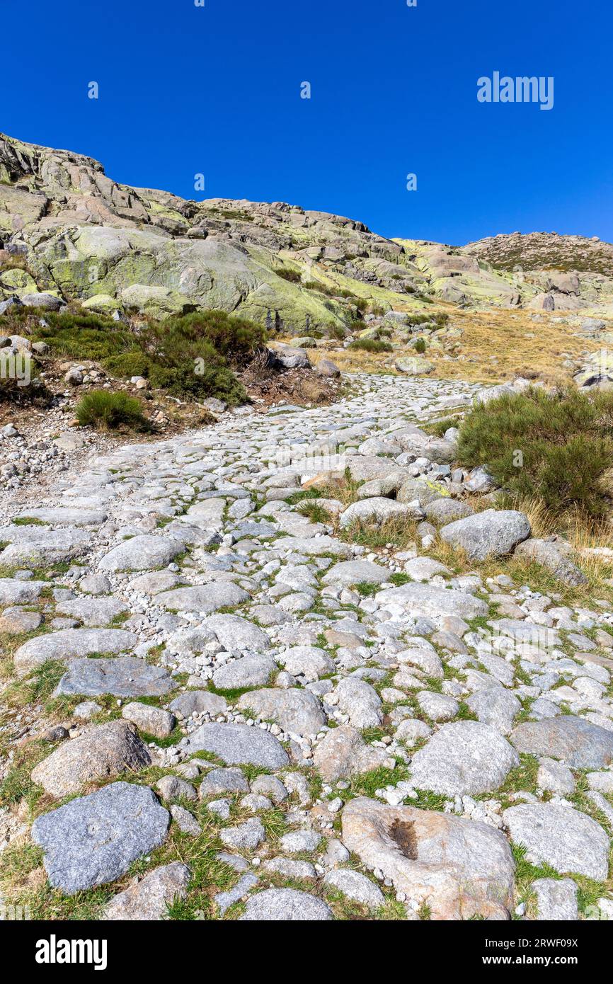 Stone hiking trail to the Laguna Grande de Gredos lake from the Plataforma de Gredos in Sierra de Gredos mountains, dry brown grass, autumn, Spain. Stock Photo