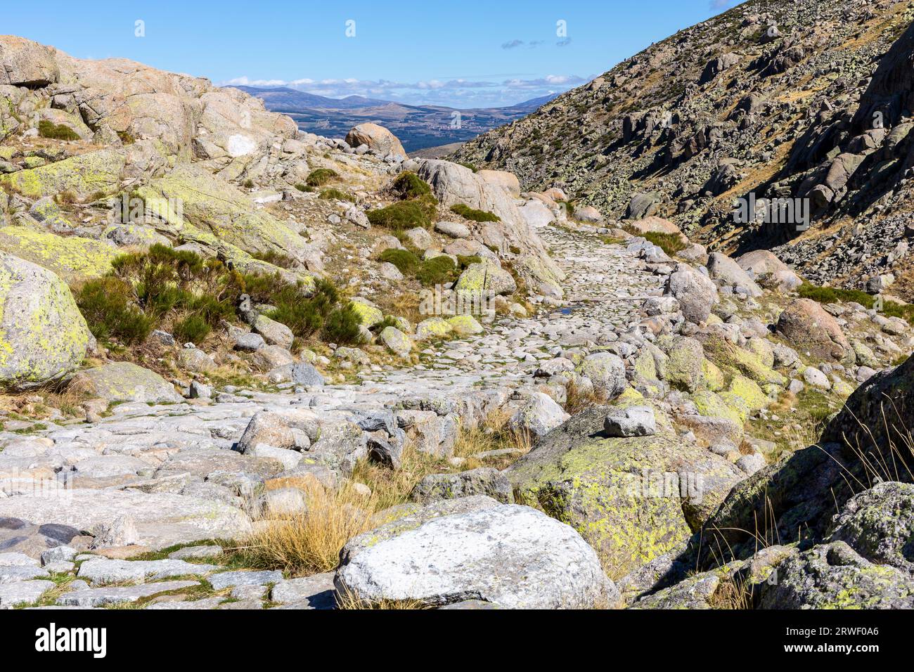 Stone hiking trail to the Laguna Grande de Gredos lake from the Plataforma de Gredos in Sierra de Gredos mountains, dry brown grass, autumn, Spain. Stock Photo