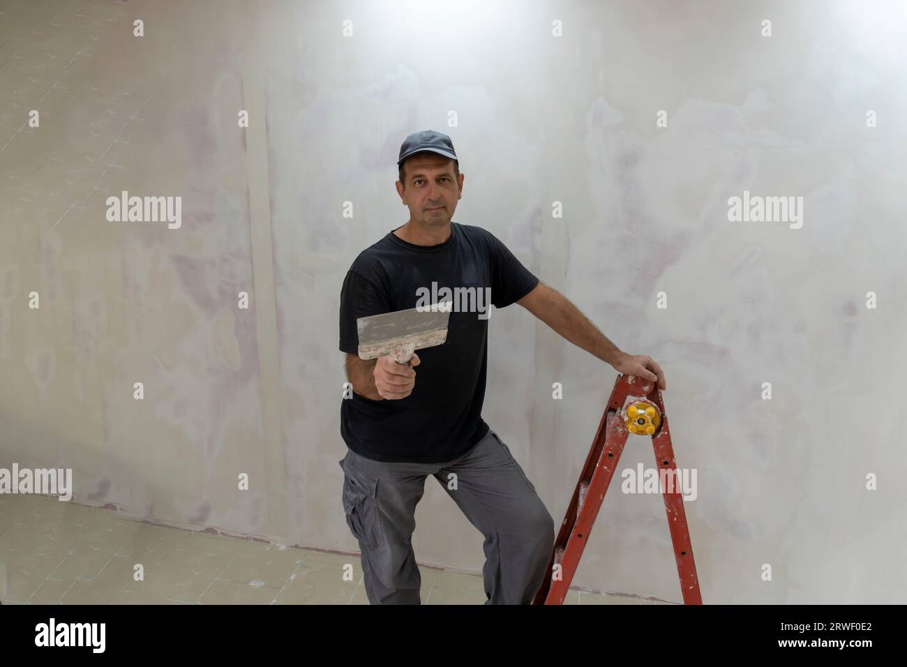 Male builder, master office, plasterer with a tool in working clothes Stock Photo