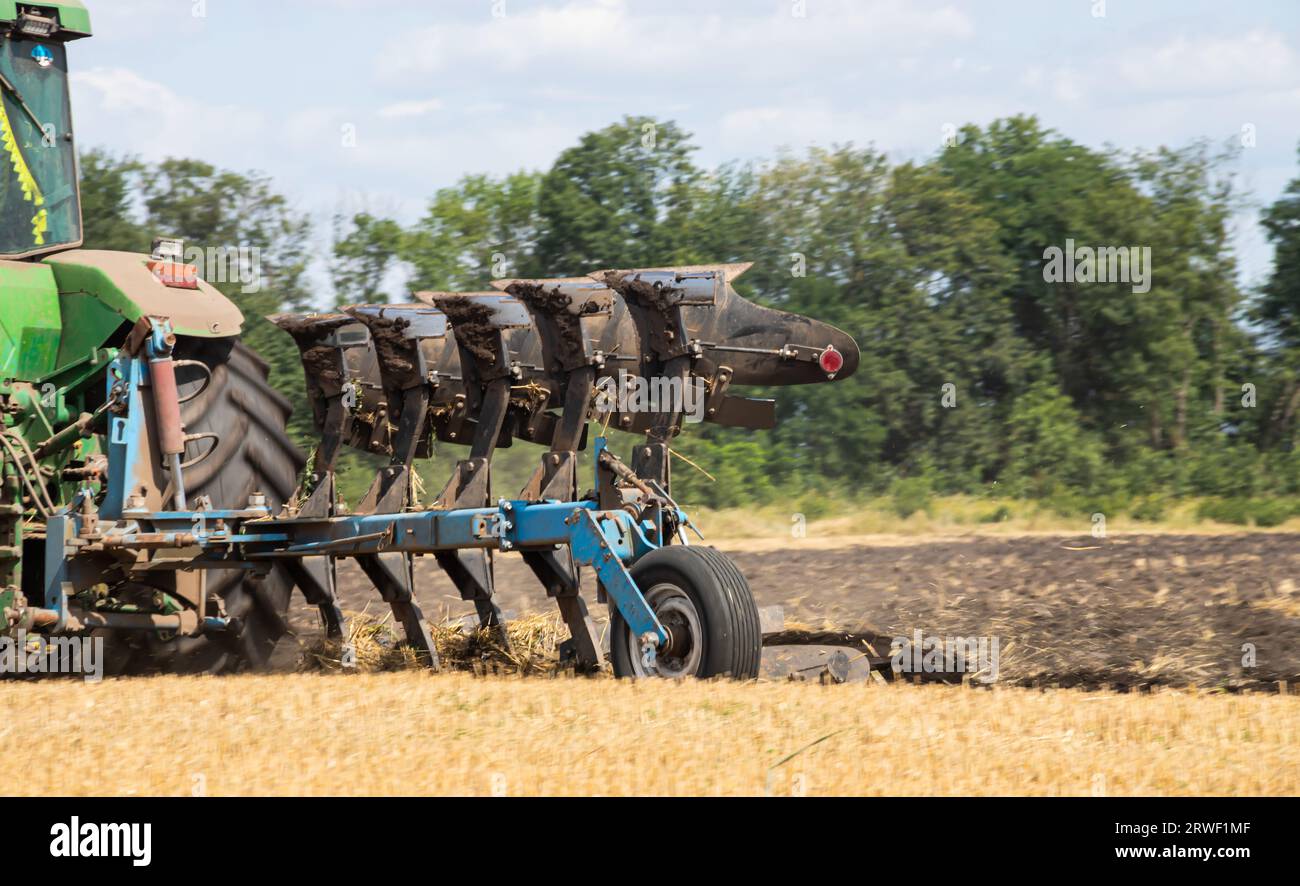 Agricultural tractor plowing a field before sowing. Stock Photo