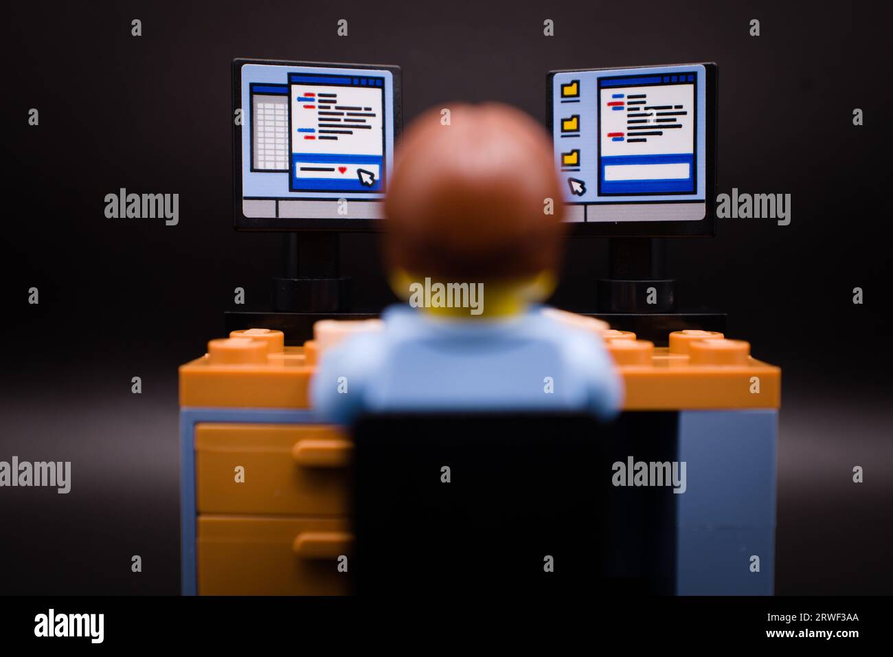 IT guy sitting in front of his computer with multiple screens Stock Photo