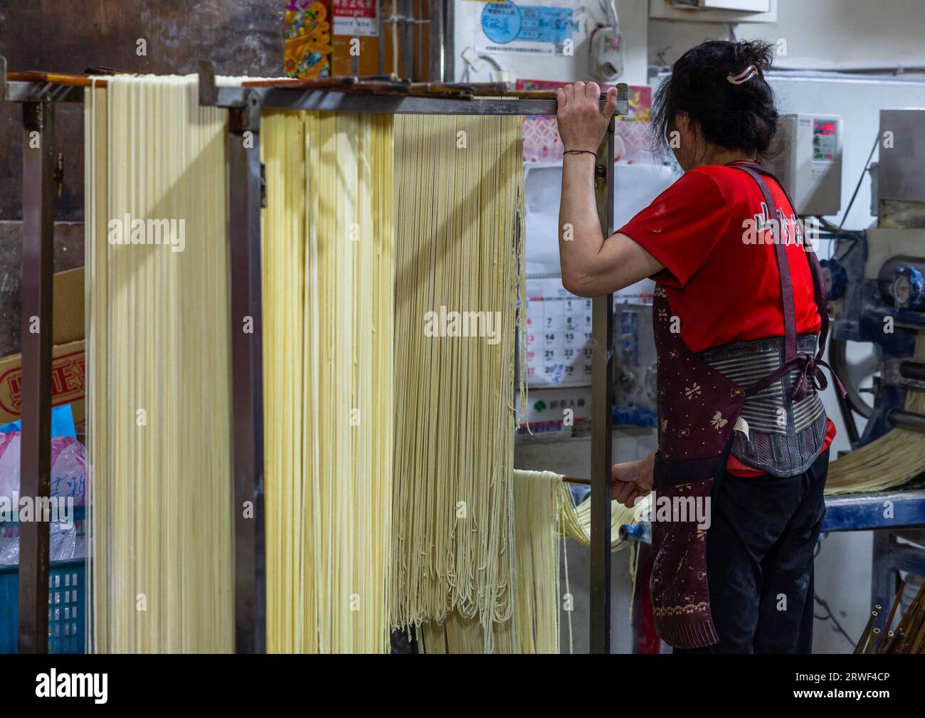 Taiwanese people hanging rice noodles in a shop, New Taipei, Tamsui, Taiwan Stock Photo