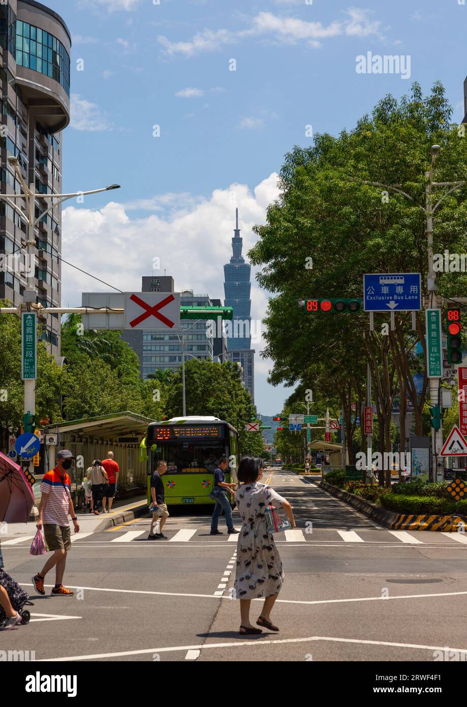 Taiwanese people crossing a road in front of 101 tower, Daan District, Taipei, Taiwan Stock Photo