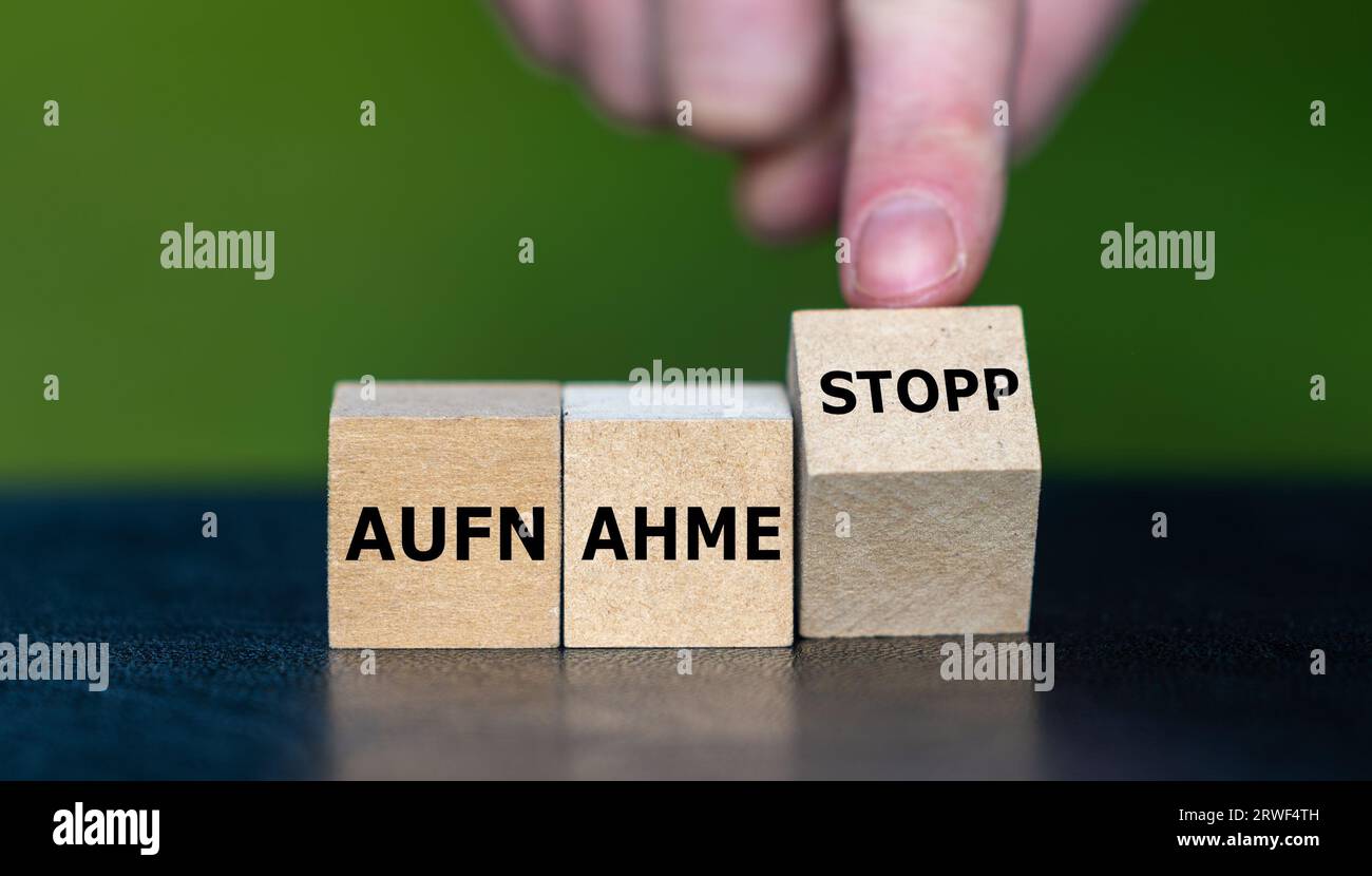 Wooden cubes form the German expression 'Aufnahme stopp' (migration stop). Stock Photo