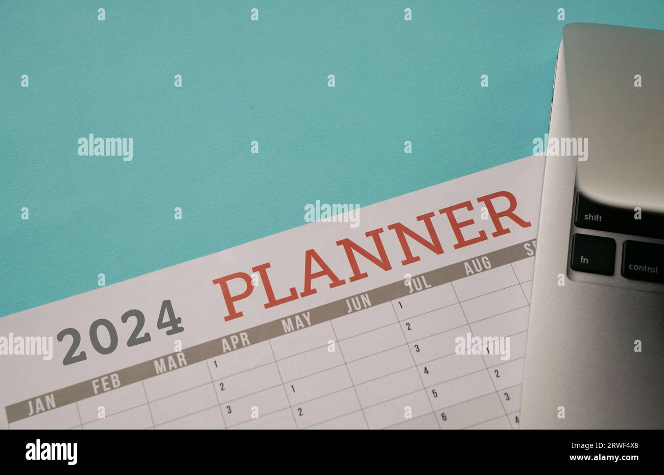 2024 Planner with computer laptop. Top view with copy space. Stock Photo