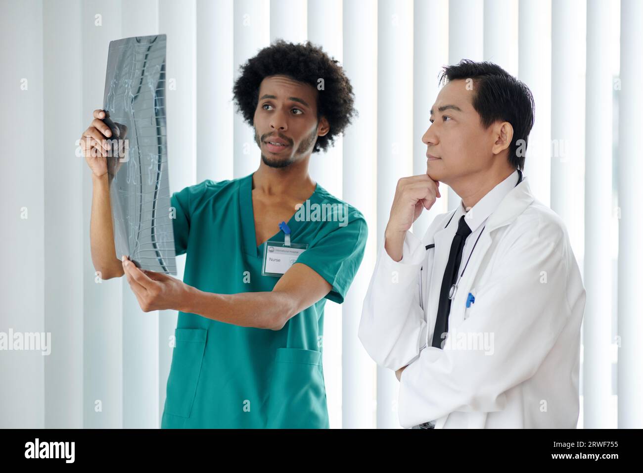 Nurse showing spine xray of patient to doctor Stock Photo