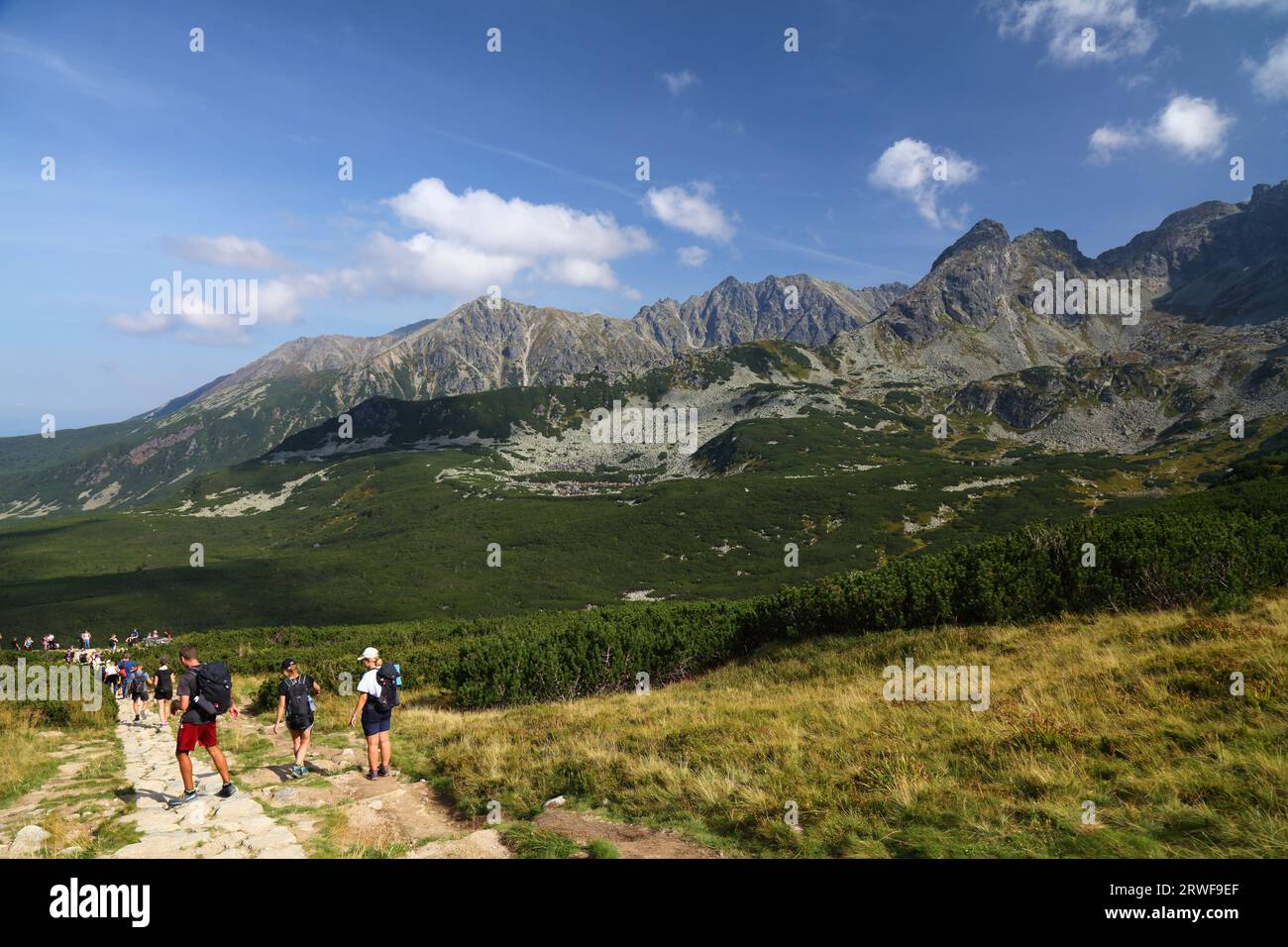 TATRA MOUNTAINS, POLAND - SEPTEMBER 9, 2023: Tourists hike the yellow trail in Dolina Gasienicowa valley in Tatrzanski Park Narodowy (Tatra National P Stock Photo