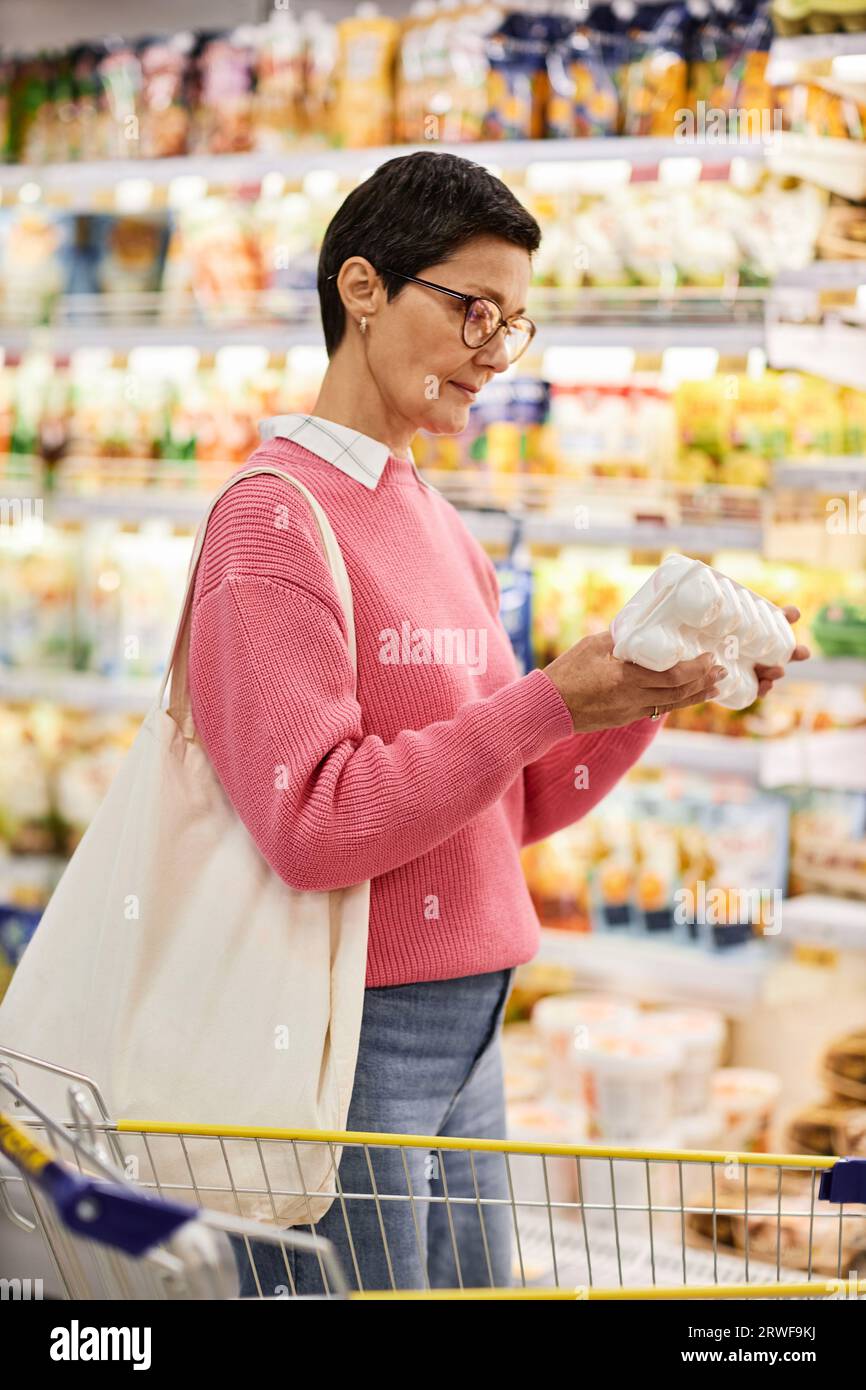 Vertical side view portrait woman holding carton of eggs in supermarket and checking expiration