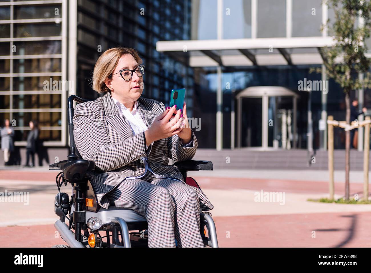 businesswoman using wheelchair using mobile phone Stock Photo
