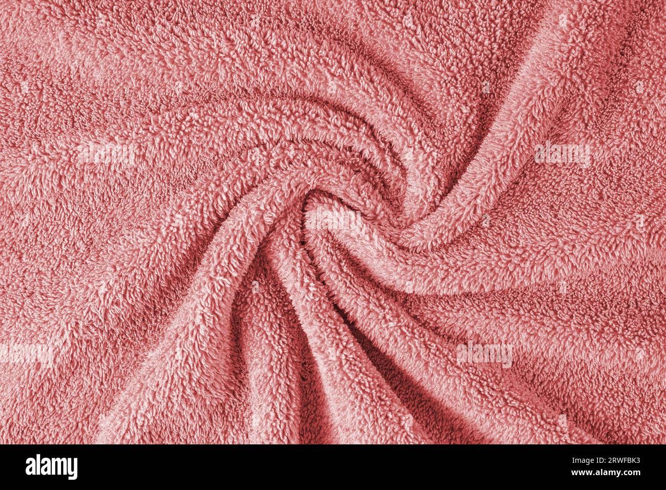 Terry cloth, red towel texture background. Wrinkled and crumped soft fluffy textile bath or beach towel material. Top view, close up. Stock Photo