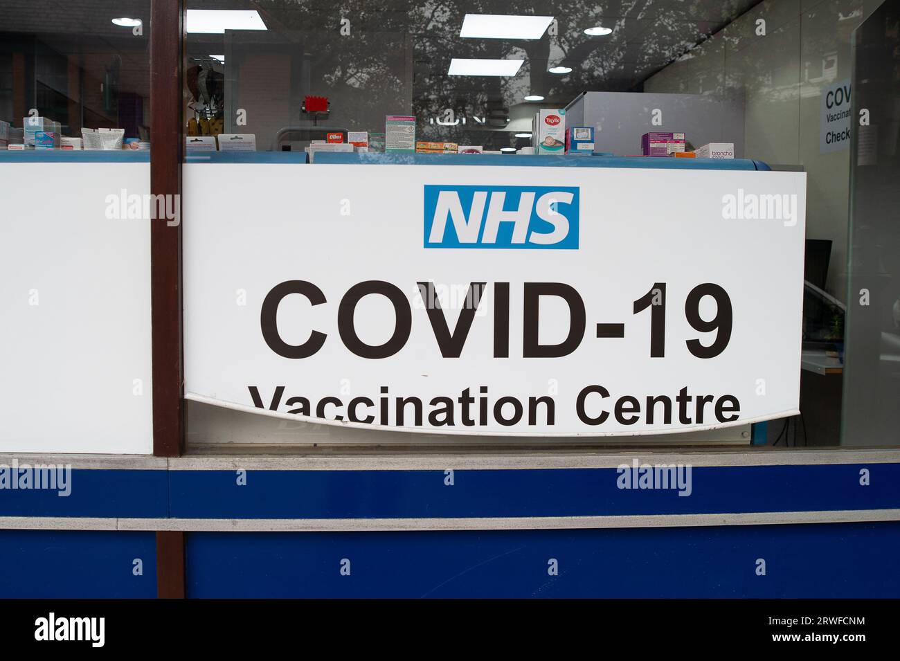 Harefield, UK. 18th September, 2023. An NHS Covid-19 Vaccination Centre sign at a pharmacy in Harefield. People aged 65 and over are being urged to get their Covid-19 Autumn booster jabs as cases are continuing to rise across the UK. The rollout of the Autumn vaccinations has been brought forward as a precaution against a highly-mutated new Covid variant called BA.2.86. Many people who are aged under 65 are concerned that they are no longer eligible for a Covid-19 booster vaccination or a flu jab as it appears the Government are cutting costs. Credit: Maureen McLean/Alamy Stock Photo