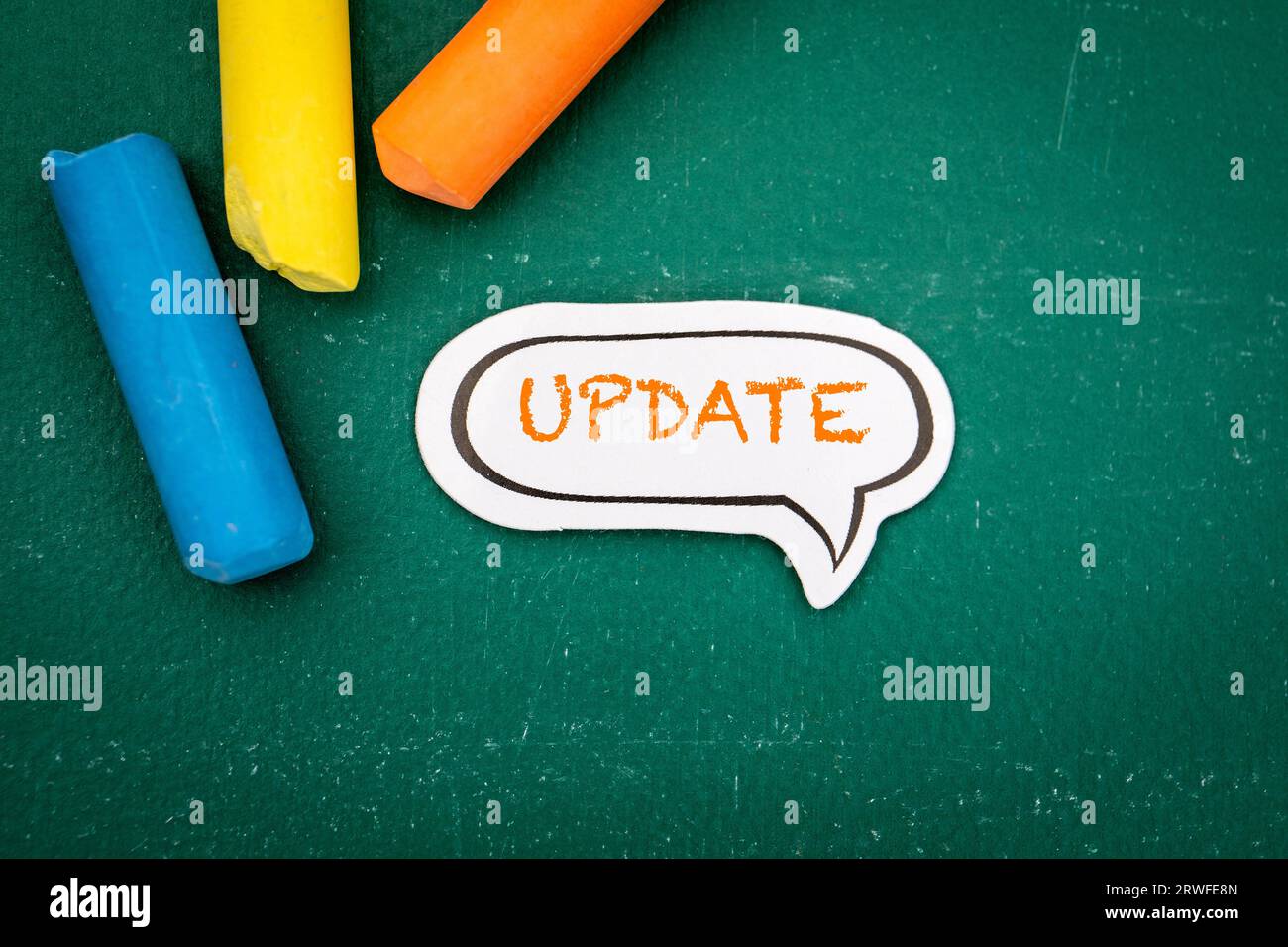 UPDATE Concept. Speech bubble on a green chalkboard background. Stock Photo