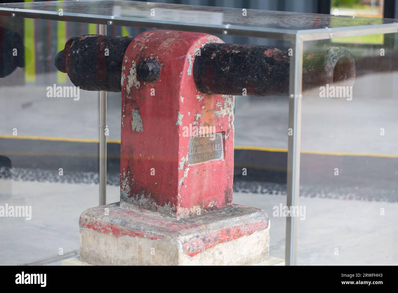 An old cannon structure in an enclosed transparent casing. This gun dated back in 1957 is on display for the public to view the heritage. Singapore Stock Photo