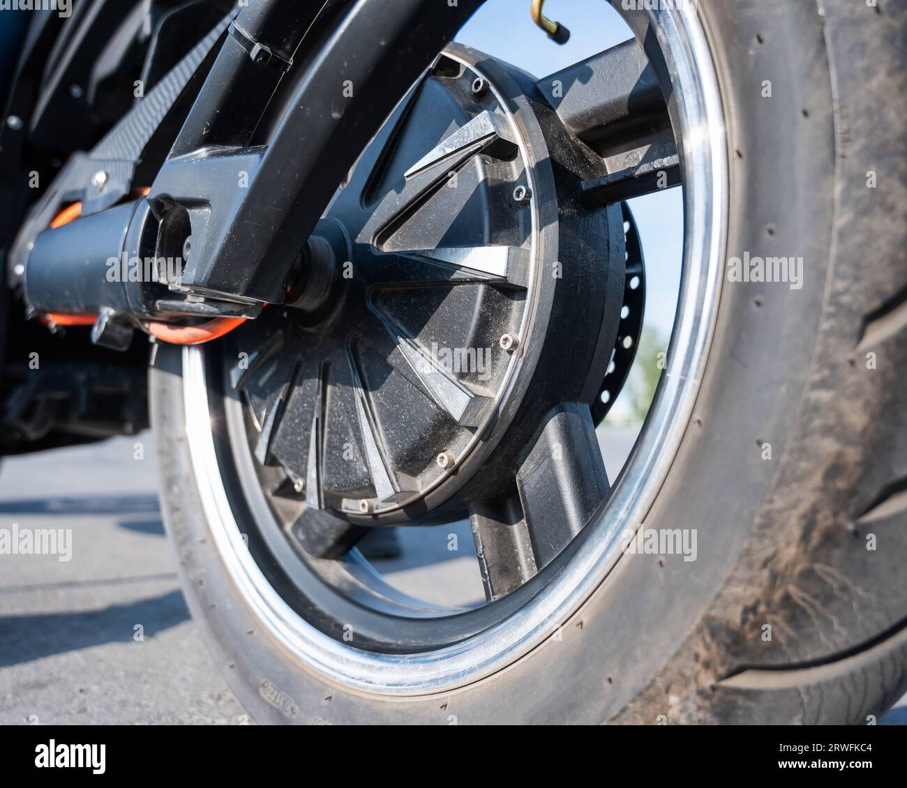 Engine Behind Rear Wheel Close-up of the rear wheel with the engine of an electric motorcycle ...