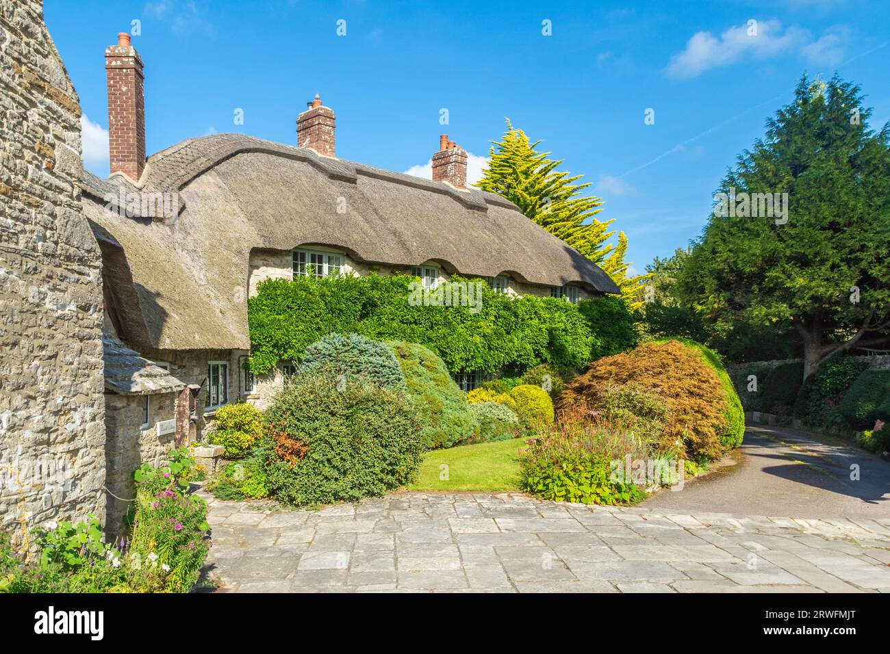East Street, Corfe Castle, UK - September 14th 2023: Thatched cottage and garden in the village. Stock Photo