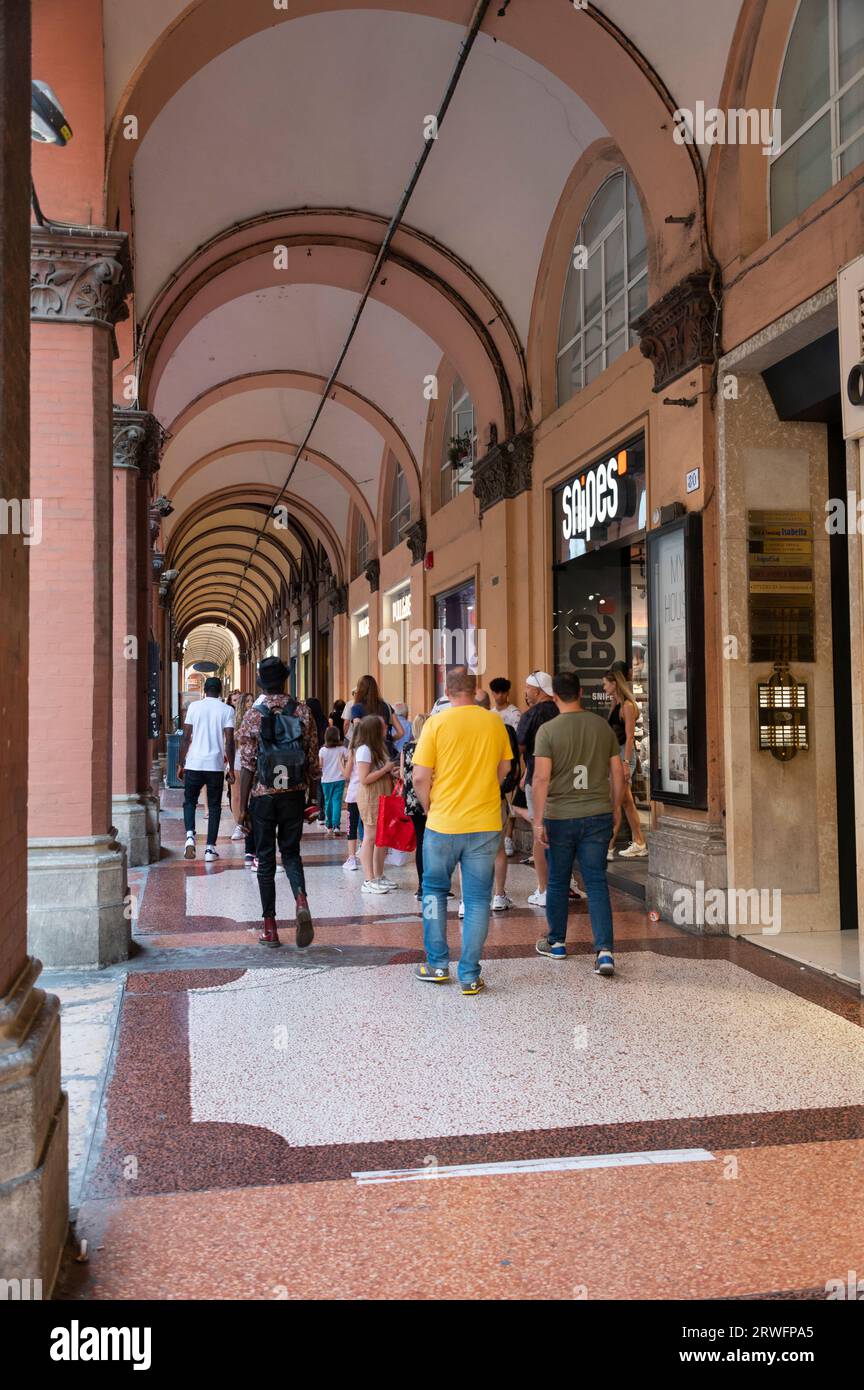 Shoppers are able to enjoy shopping under the covered long high ceiling portico or colonnades with a roof structure over a walkway supported with larg Stock Photo