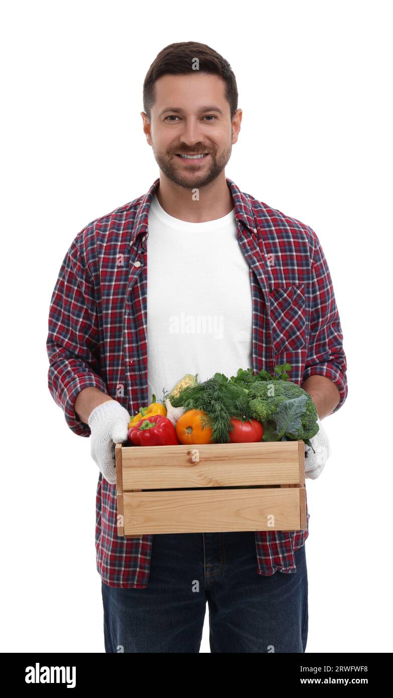 Harvesting season. Happy farmer holding wooden crate with vegetables on ...