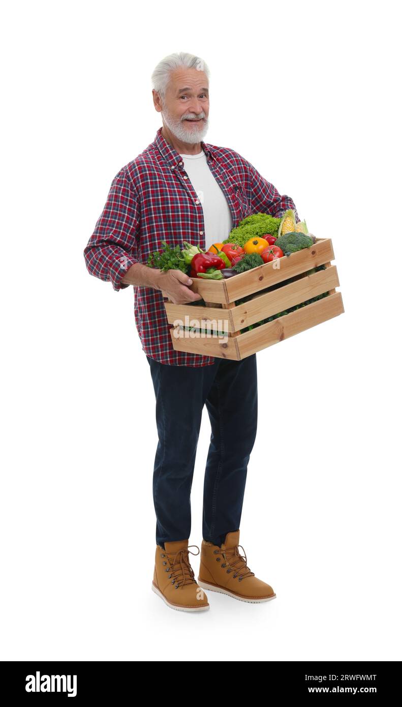 Harvesting season. Happy farmer holding wooden crate with vegetables on ...