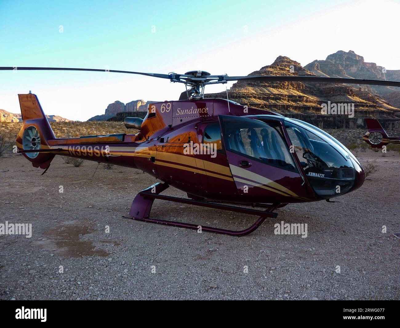 Helicopter pleasure flight into the Grand Canyon at sunset. Eurocopter EC130 B4 helicopter of Sundance Helicopters on canyon floor Stock Photo