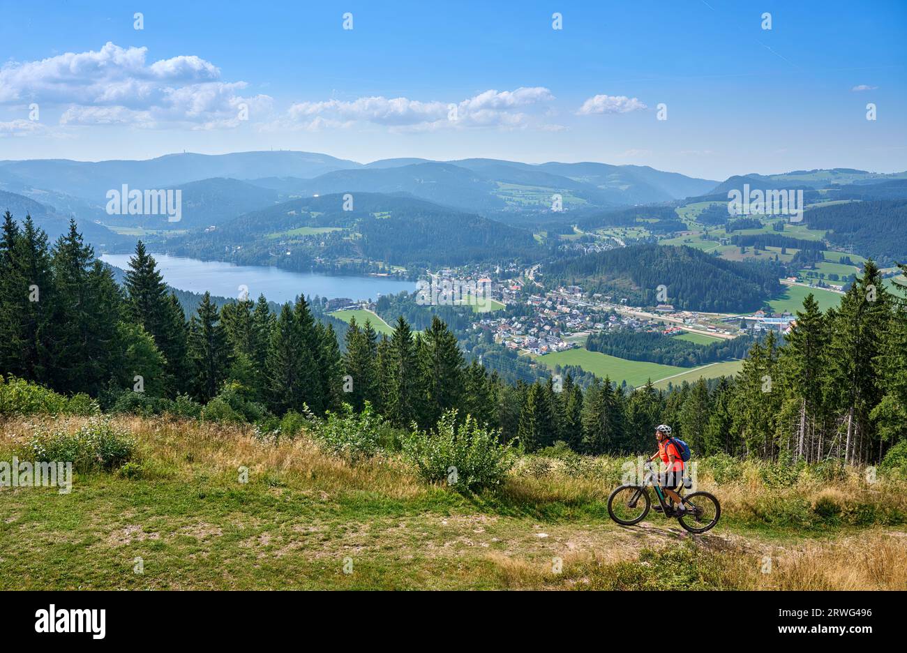 nice senior woman on her electric mountain bike cycling in the German Black Forest above Lake Titisee, Baden-Württemberg, Germany Stock Photo