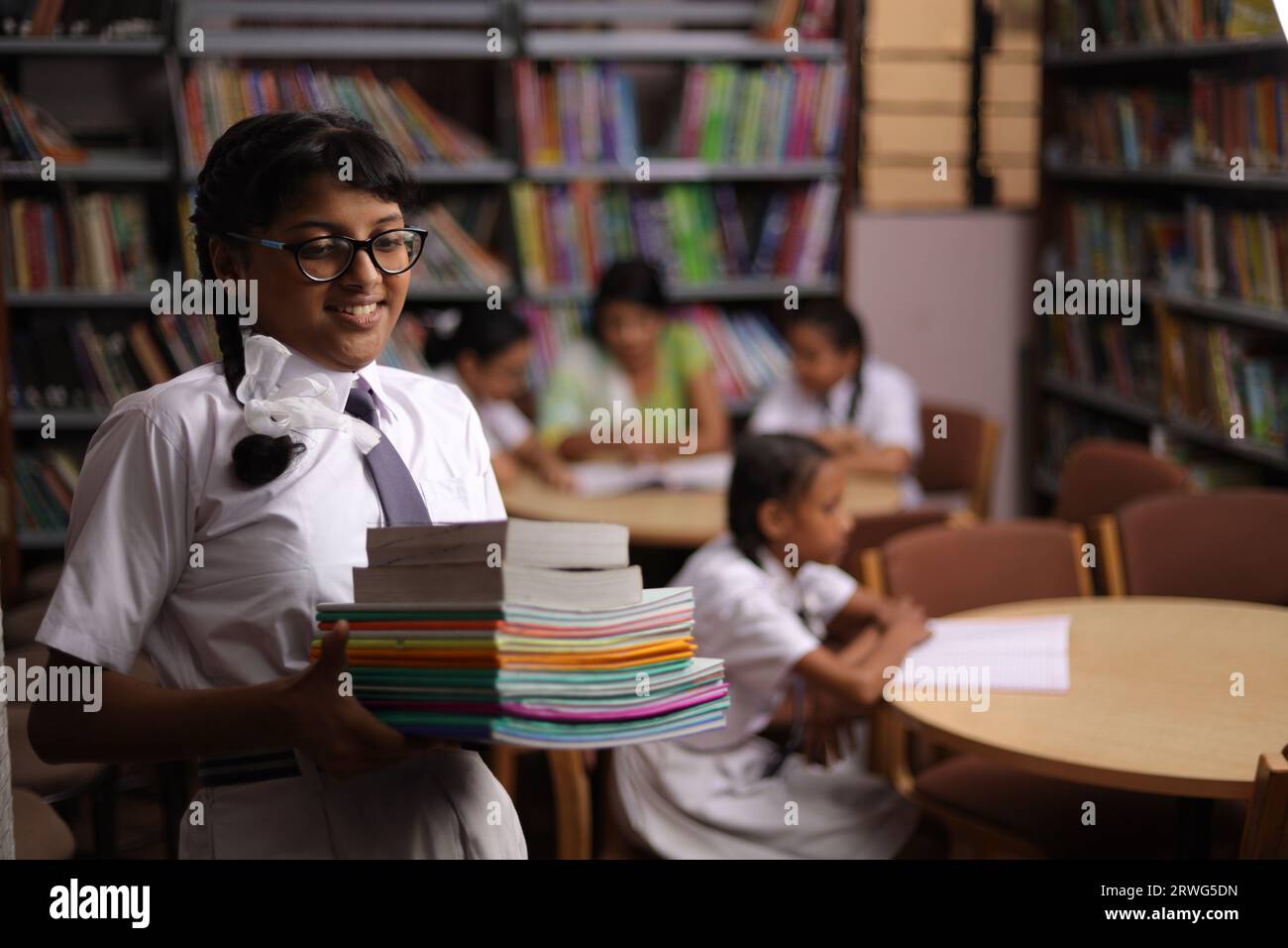 Happy teenager girl student holding books in her hand, standing in ...