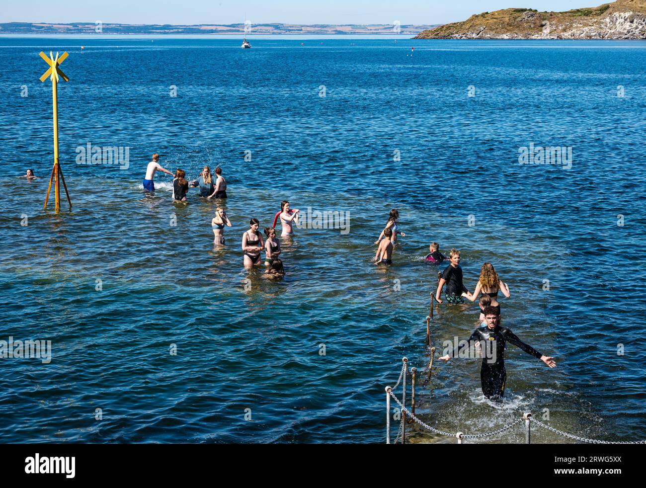 Children swiming in sea in hot Summer weather, North Berwick harbour, East Lothian, Scotland, UK Stock Photo