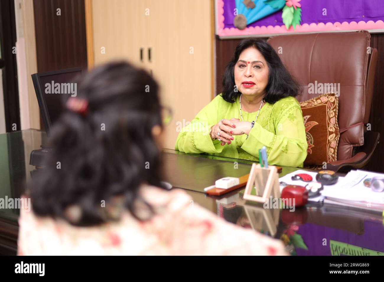 Happy school Principal mam talking about a student with the parent, PTM, Parents teacher meeting, smiling. Stock Photo