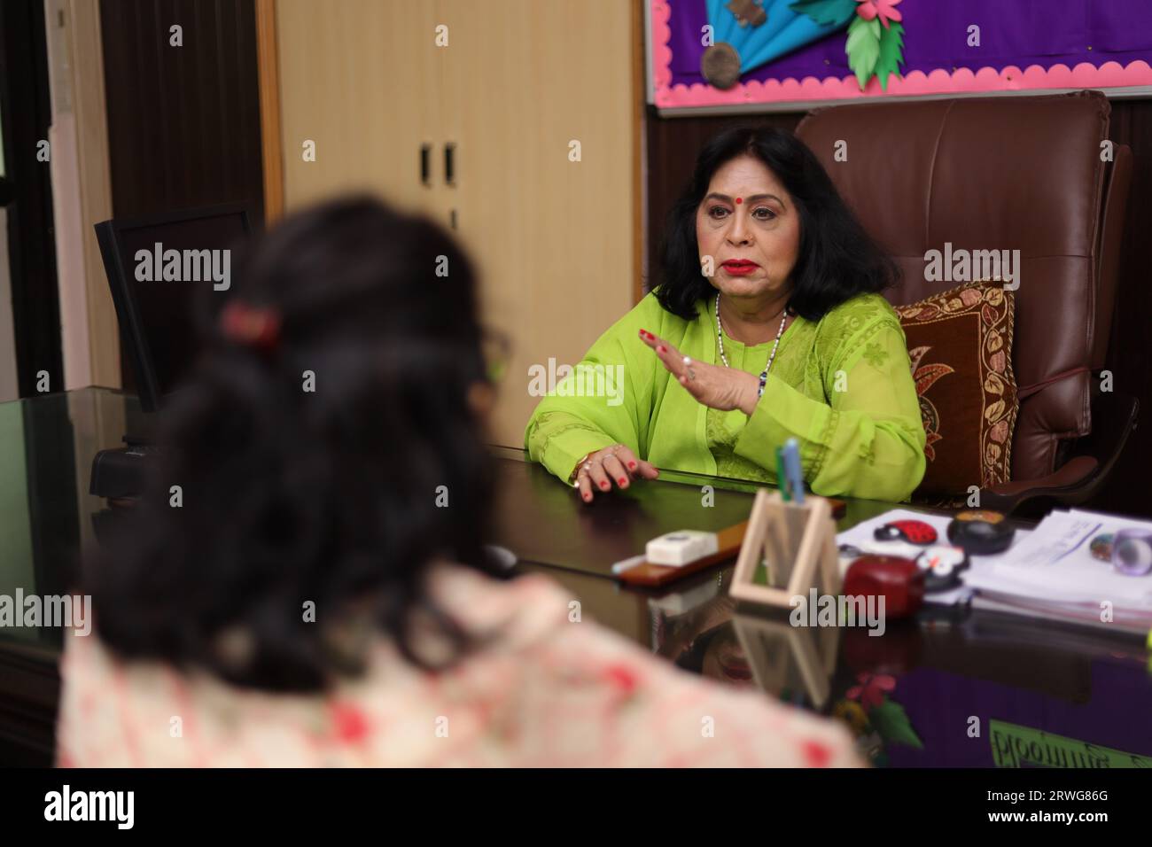 Happy school Principal mam talking about a student with the parent, PTM, Parents teacher meeting, smiling. Stock Photo