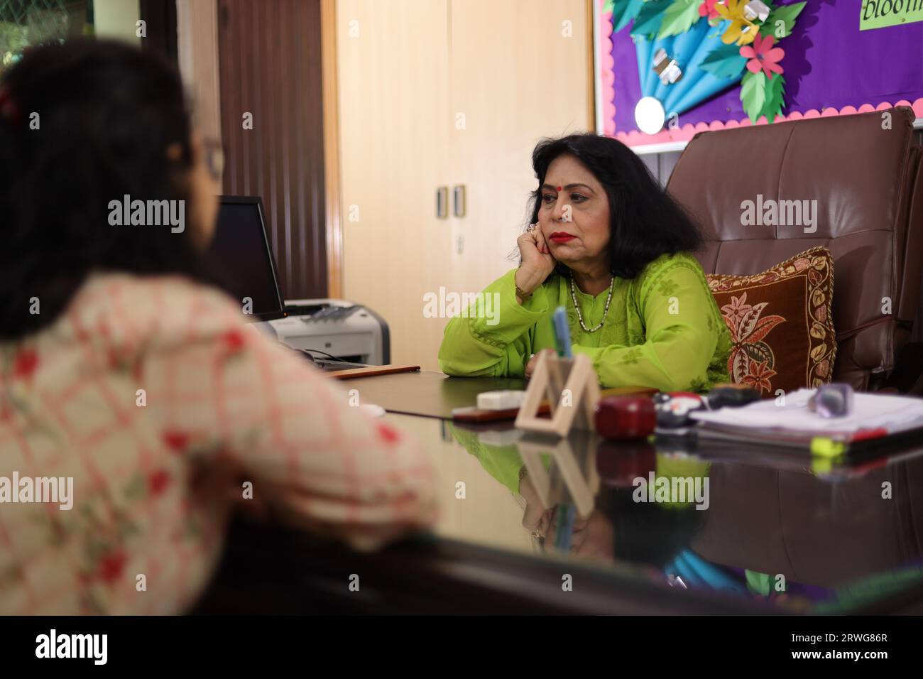 Happy school Principal mam talking about a student with the parent, PTM, Parents teacher meeting, smiling. Stock Photo