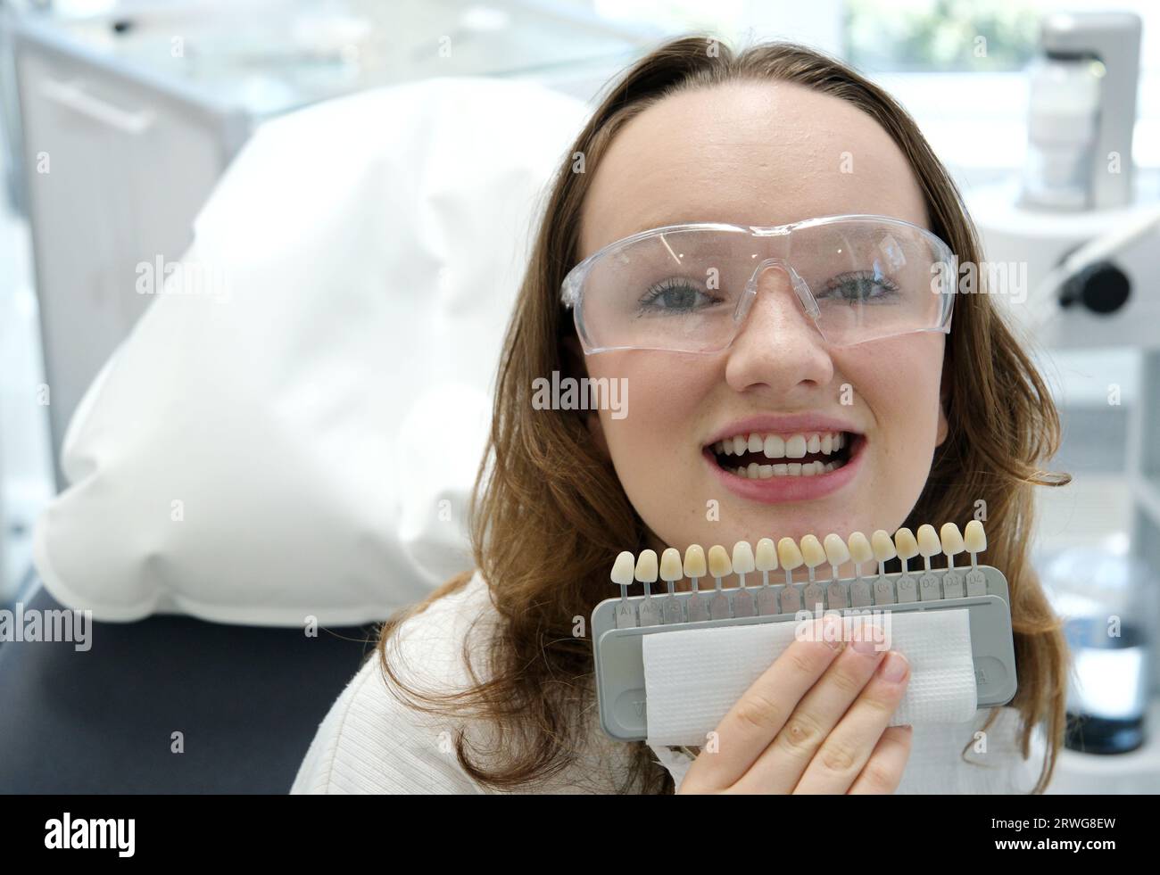 tooth whitening, perfect white crown teeth close up with shade guide